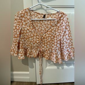 Light orange/tan quarter sleeve blouse. Adjustable front with string.